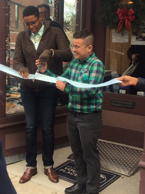 Tj and Ren laugh as they hold scissors and cut ribbon